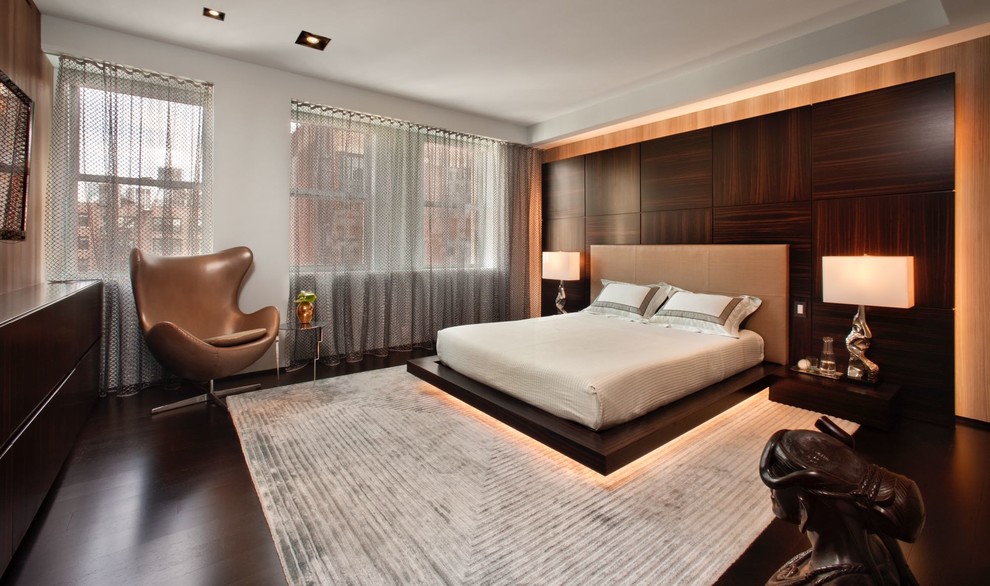 Design ideas for a large modern master and grey and brown bedroom in New York with grey walls, dark hardwood flooring, no fireplace and brown floors.