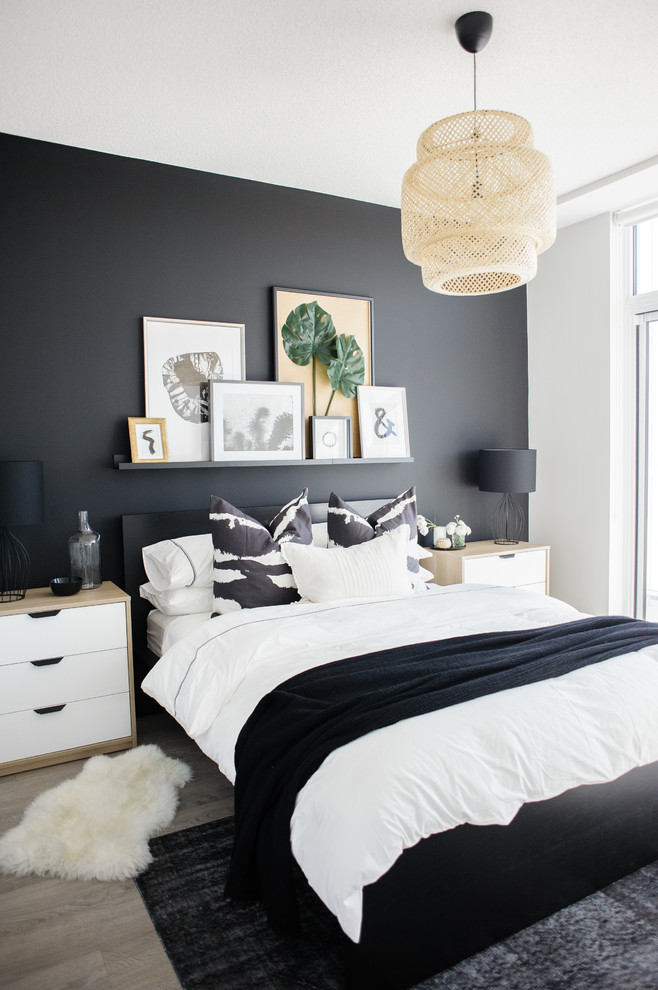 Inspiration pour une chambre design avec un mur noir, parquet clair et un sol beige.