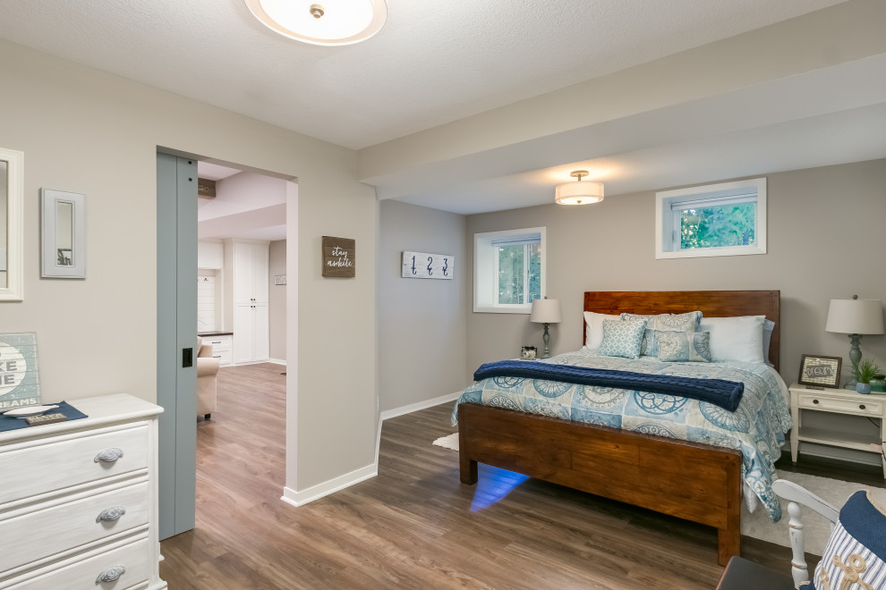 Foto de dormitorio principal costero grande con paredes beige, suelo de madera clara y suelo beige