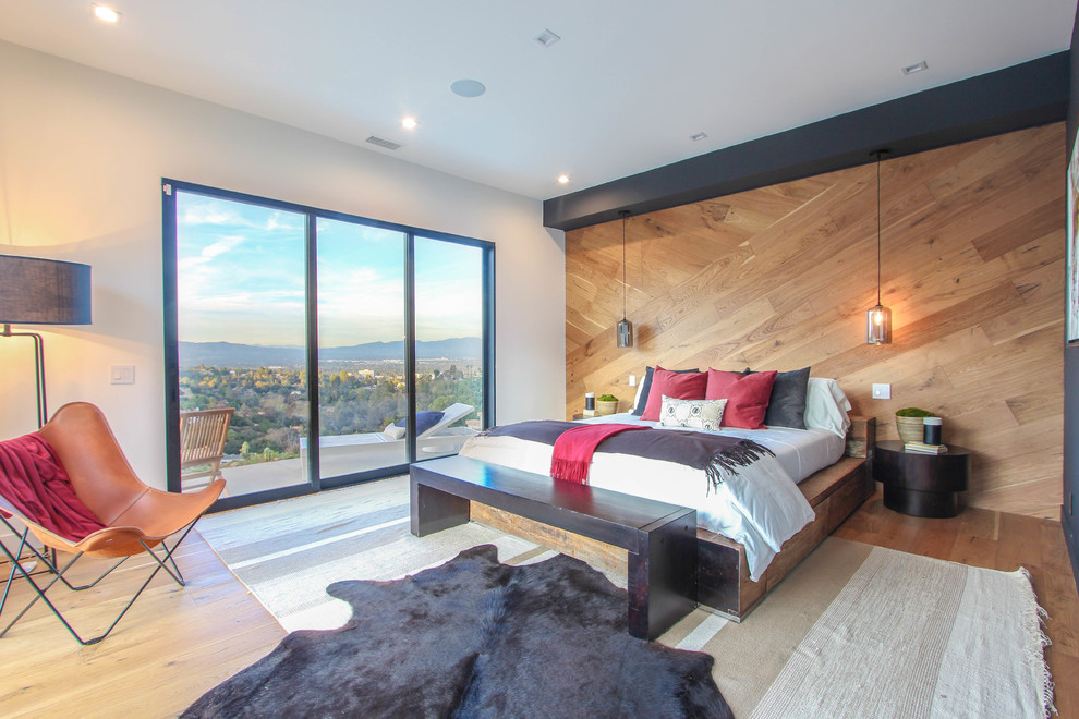Großes Modernes Hauptschlafzimmer ohne Kamin mit schwarzer Wandfarbe, braunem Holzboden und braunem Boden in Los Angeles