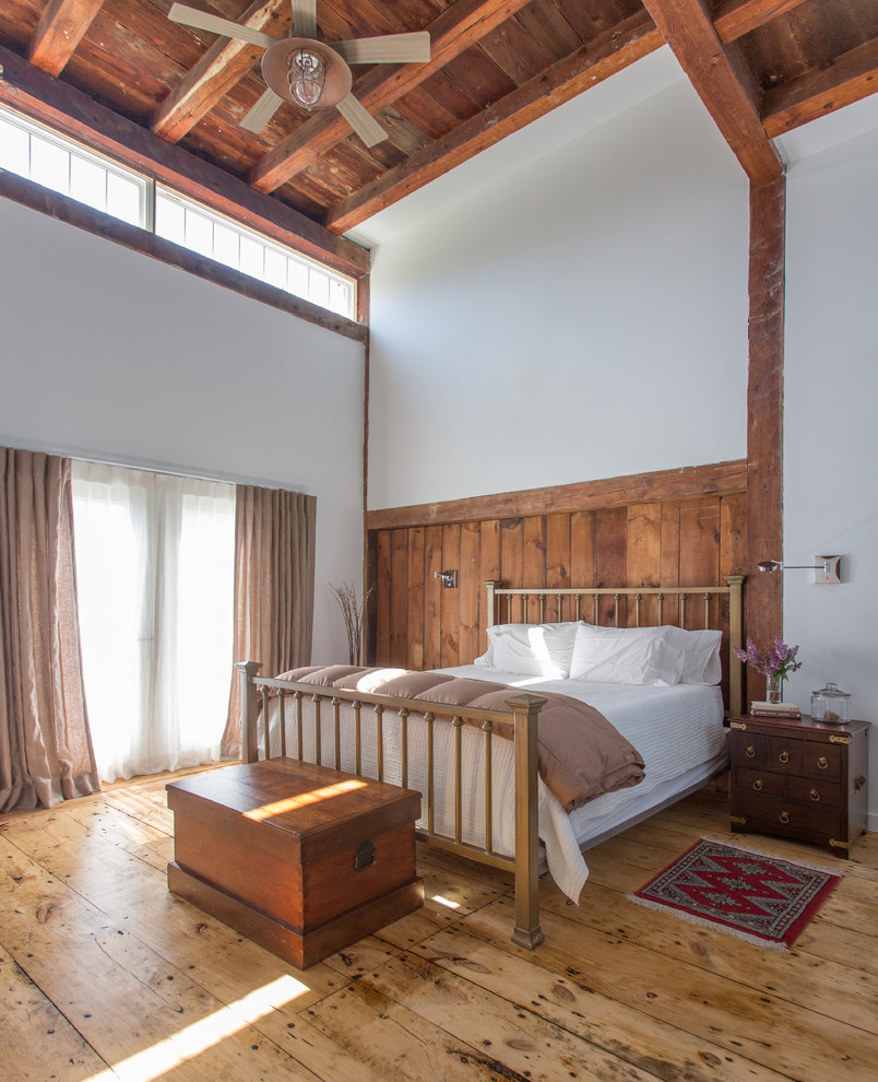 Modelo de dormitorio campestre extra grande con suelo de madera clara