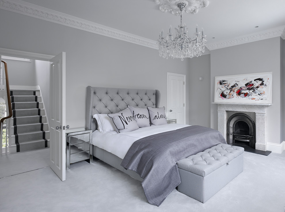 This is an example of a contemporary master bedroom in London with grey walls, carpet, a standard fireplace and grey floors.