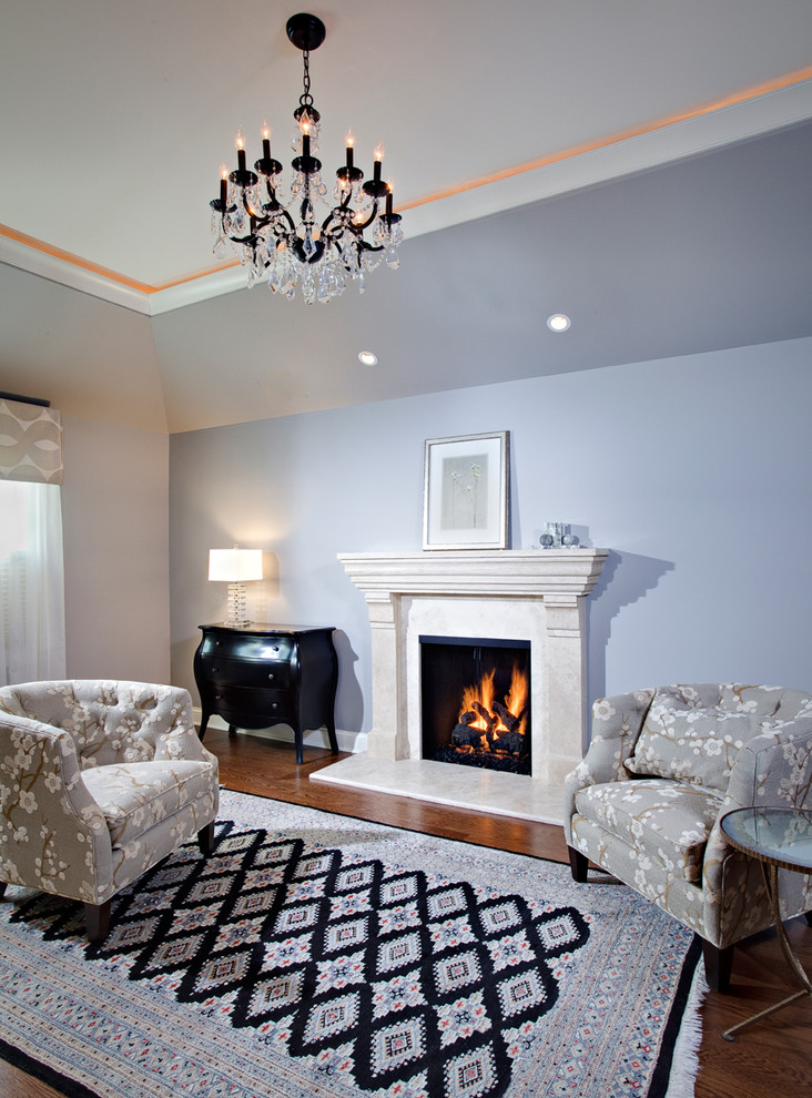 Aménagement d'une grande chambre parentale classique avec un mur bleu, parquet foncé, une cheminée standard et un manteau de cheminée en carrelage.