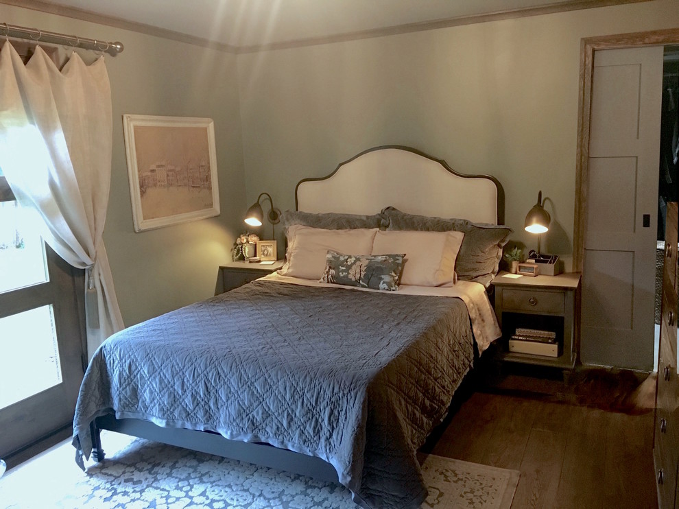 На фото: хозяйская спальня среднего размера в стиле фьюжн с серыми стенами, полом из винила, стандартным камином, фасадом камина из дерева и коричневым полом с