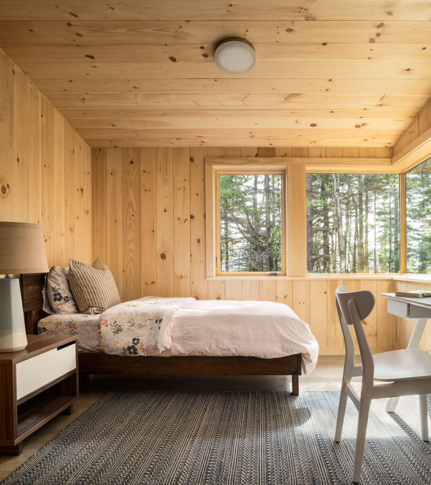 This is an example of a medium sized rustic guest and grey and brown bedroom in Portland Maine with brown walls, medium hardwood flooring and grey floors.