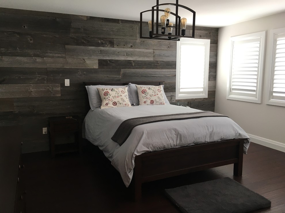 This is an example of a farmhouse master bedroom in Toronto with beige walls, bamboo flooring, a two-sided fireplace and brown floors.