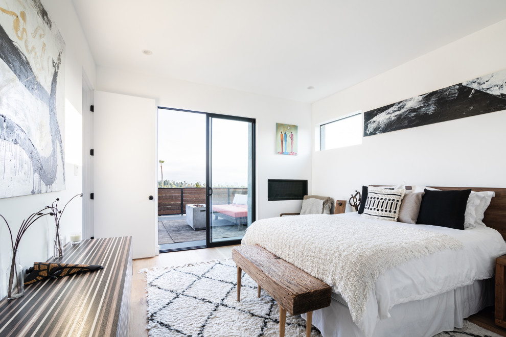 ロサンゼルスにある中くらいなコンテンポラリースタイルのおしゃれな主寝室 (白い壁、無垢フローリング、標準型暖炉、金属の暖炉まわり、茶色い床) のインテリア