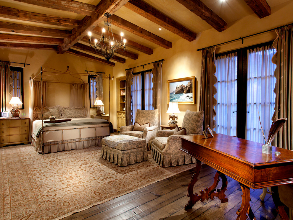 Großes Mediterranes Hauptschlafzimmer ohne Kamin mit beiger Wandfarbe und dunklem Holzboden in Phoenix