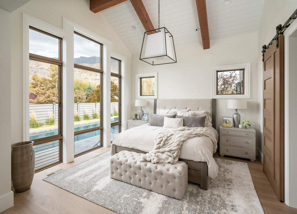 Großes Landhausstil Hauptschlafzimmer mit weißer Wandfarbe, braunem Holzboden und braunem Boden in Salt Lake City