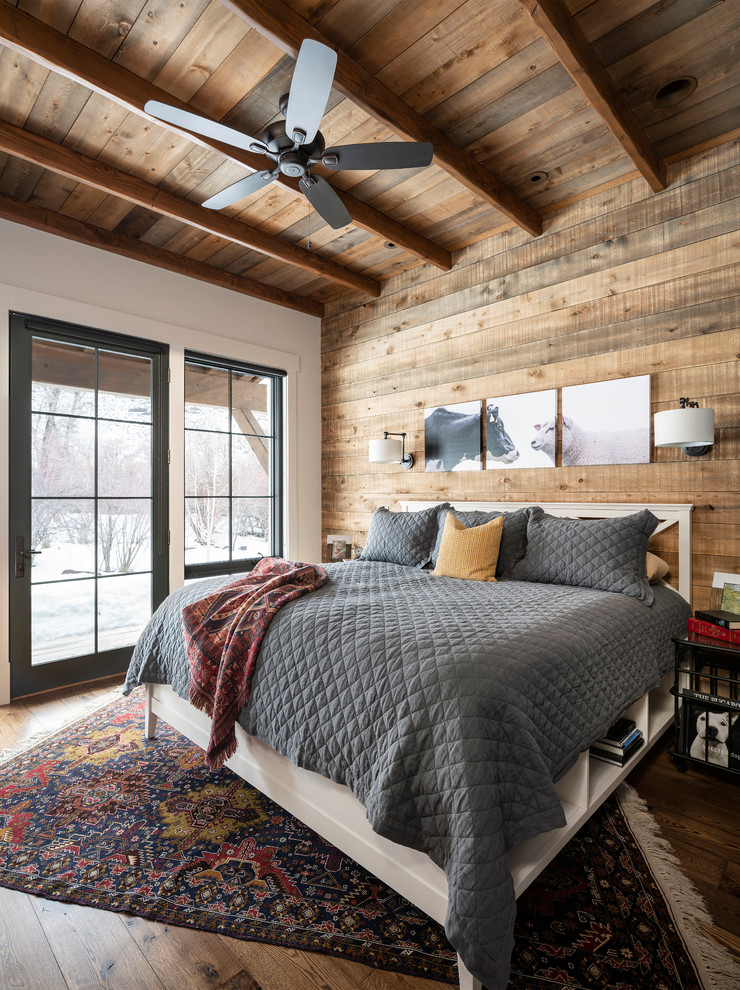 Aménagement d'une chambre campagne avec un mur blanc, parquet foncé et un sol marron.