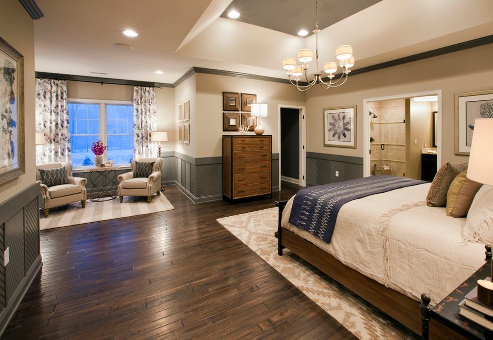 Modelo de dormitorio principal clásico extra grande con paredes beige y suelo de madera oscura