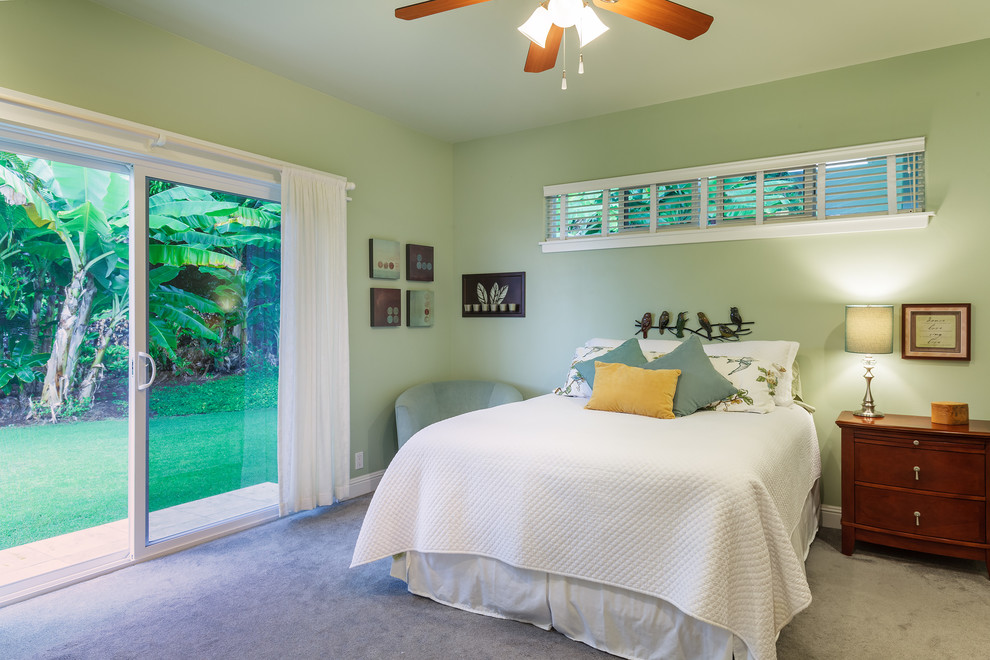 Ejemplo de habitación de invitados tropical con paredes verdes y moqueta