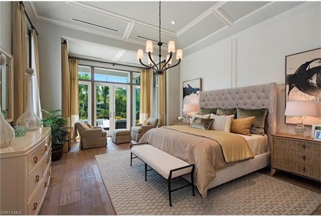Ejemplo de dormitorio principal tradicional renovado grande sin chimenea con paredes beige y suelo de madera en tonos medios