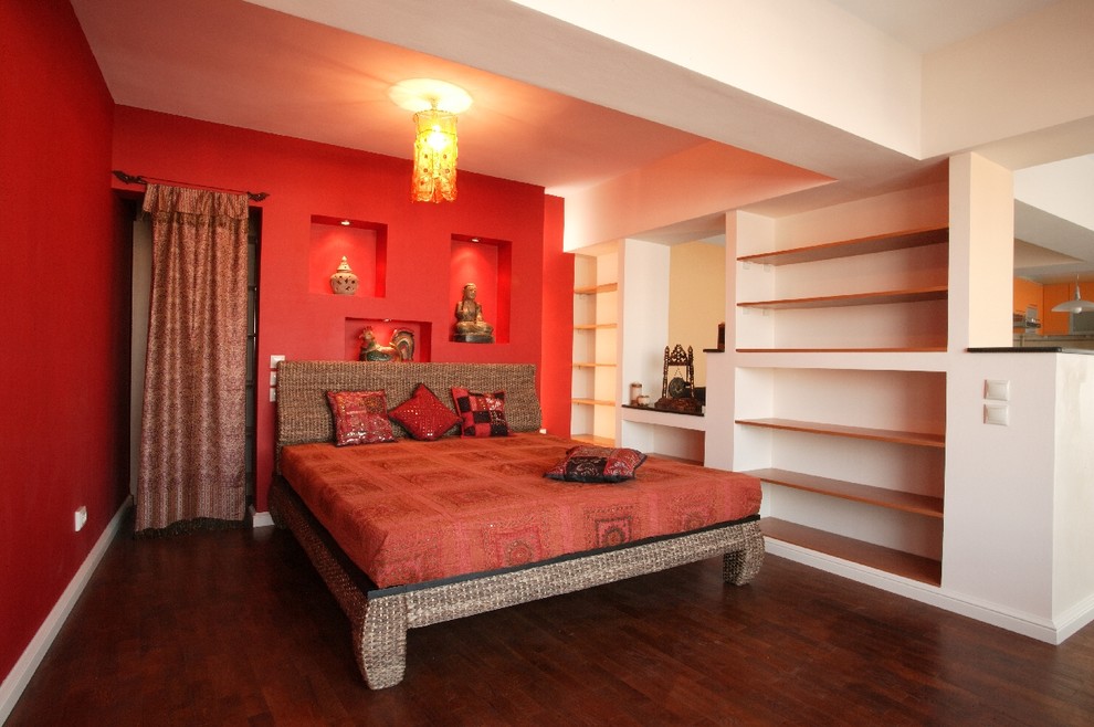 Diseño de dormitorio principal bohemio pequeño sin chimenea con paredes rojas y suelo de madera oscura