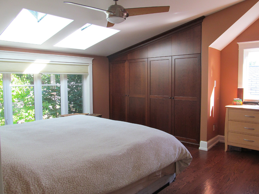Esempio di una piccola camera da letto stile loft stile americano con pareti arancioni, pavimento in legno massello medio, nessun camino e pavimento marrone