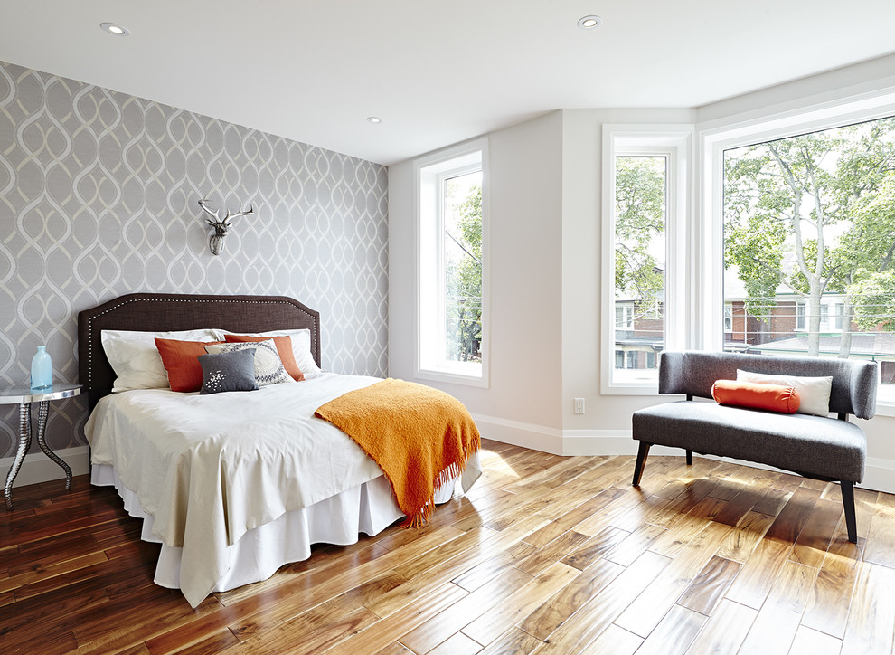 Modelo de habitación de invitados clásica renovada grande sin chimenea con paredes grises y suelo de madera en tonos medios