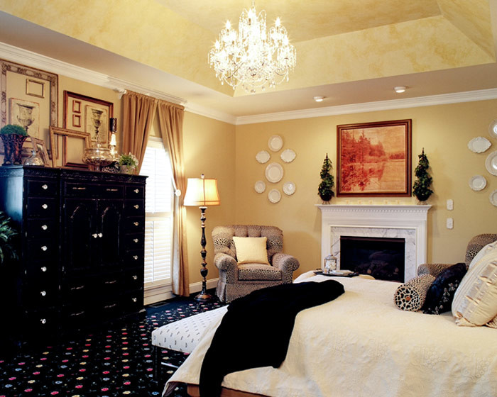 Inspiration for a mid-sized timeless master carpeted bedroom remodel in Other with yellow walls, a standard fireplace and a stone fireplace
