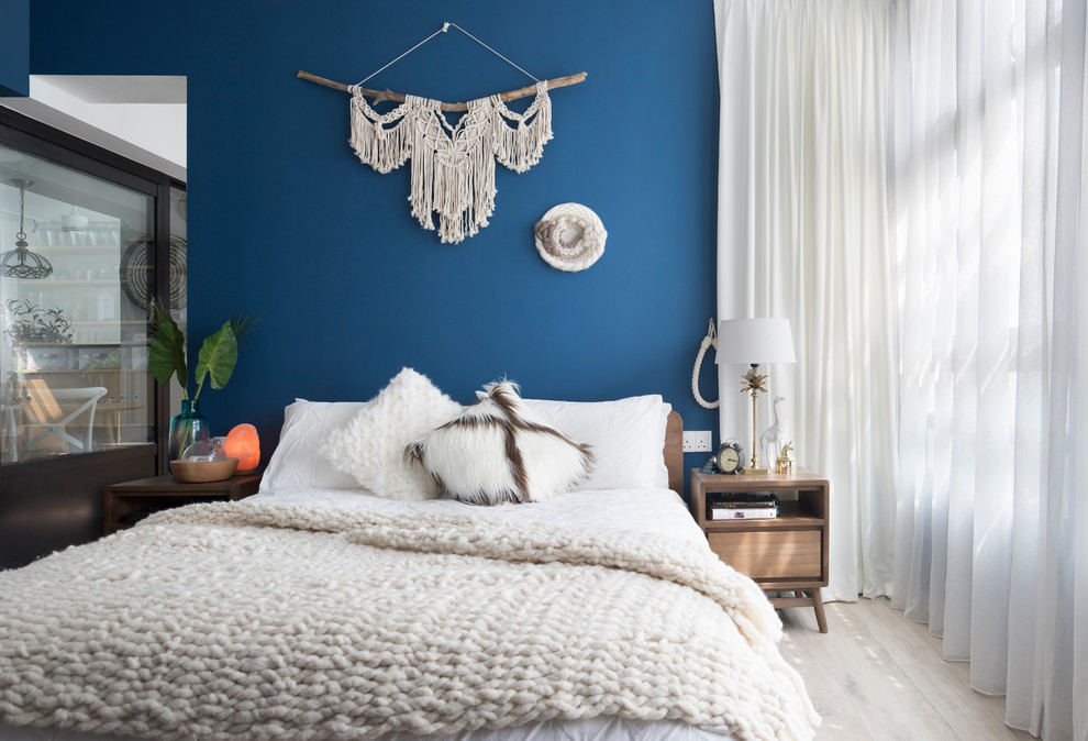 Modelo de dormitorio principal escandinavo sin chimenea con paredes azules, suelo de madera clara y suelo beige