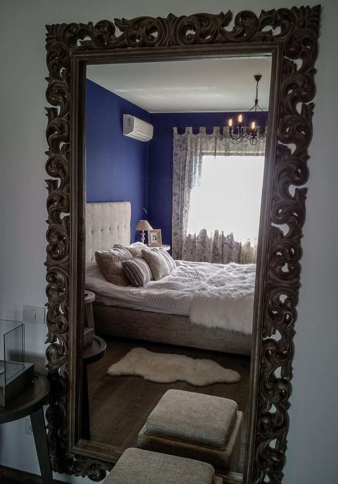 Idee per una camera matrimoniale boho chic di medie dimensioni con pareti blu e pavimento in legno massello medio