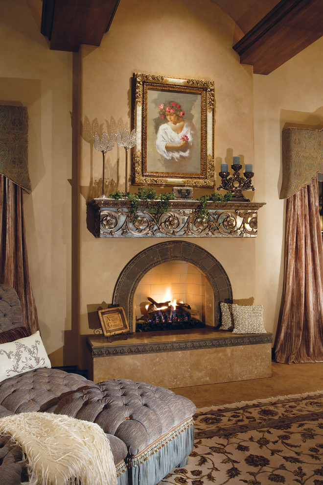 Aménagement d'une très grande chambre méditerranéenne avec un mur beige, une cheminée standard et un manteau de cheminée en métal.