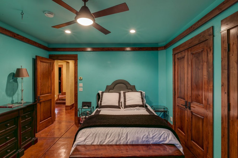 Diseño de habitación de invitados rústica de tamaño medio con paredes azules, suelo de cemento y suelo naranja
