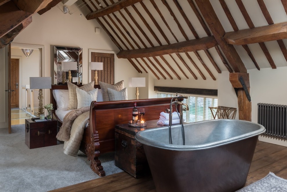 Mittelgroßes Rustikales Schlafzimmer mit beiger Wandfarbe, braunem Holzboden und braunem Boden in Gloucestershire