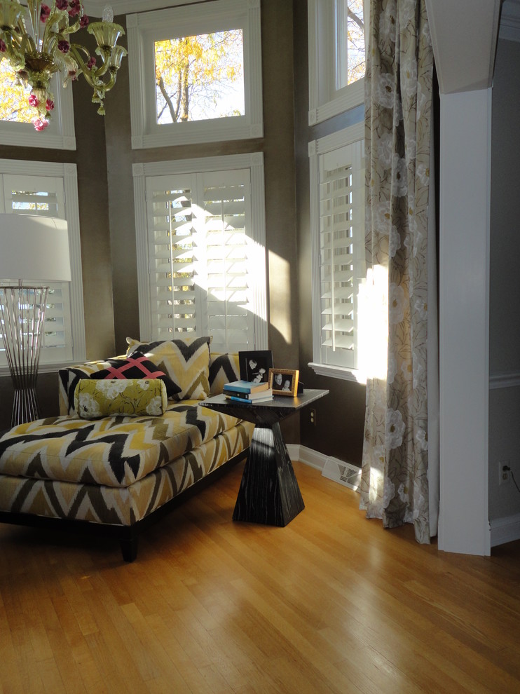 This is an example of an expansive bohemian master bedroom in Milwaukee with beige walls and medium hardwood flooring.