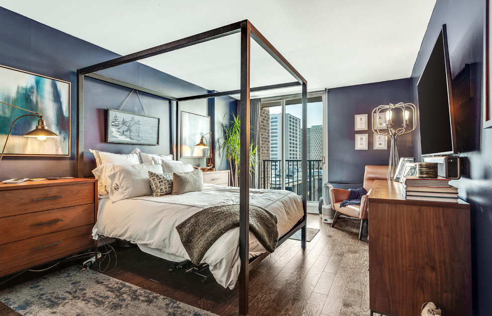 Diseño de habitación de invitados actual de tamaño medio sin chimenea con suelo de madera en tonos medios y paredes azules
