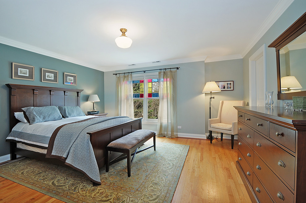 Klassisches Hauptschlafzimmer mit grüner Wandfarbe und braunem Holzboden in Chicago