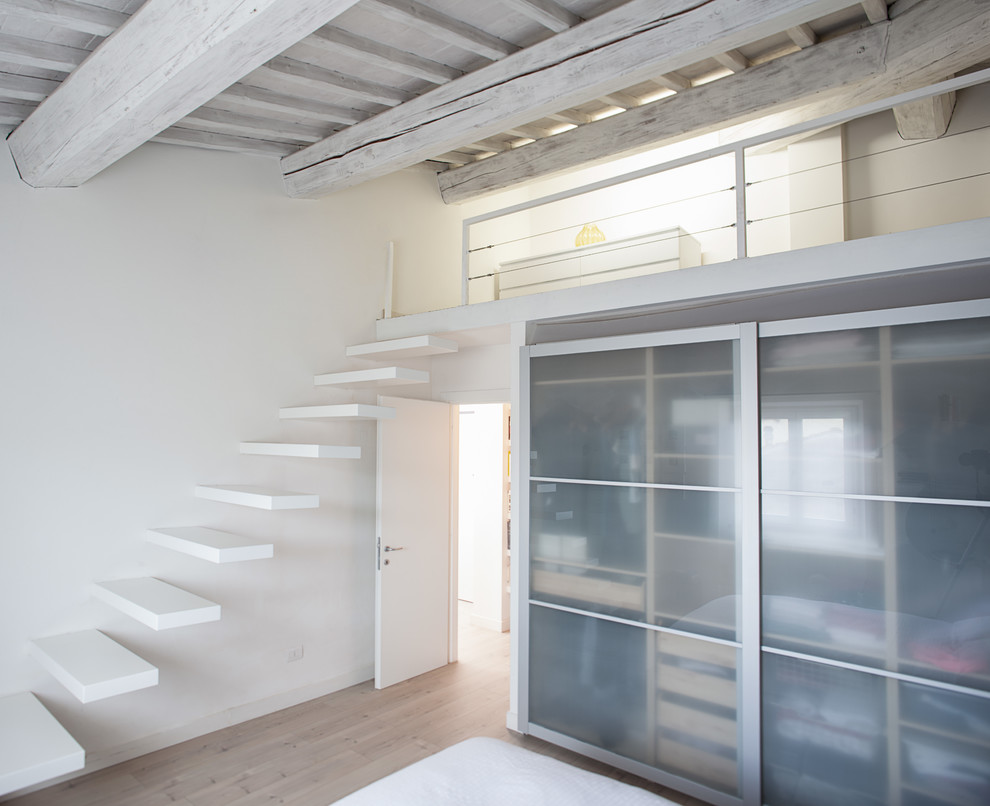 Ejemplo de dormitorio principal escandinavo pequeño con paredes blancas y suelo de madera clara