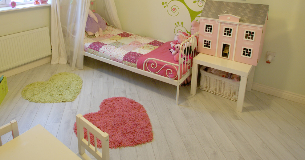 На фото: детская среднего размера в современном стиле с спальным местом, зелеными стенами, полом из ламината и белым полом для ребенка от 1 до 3 лет, девочки с