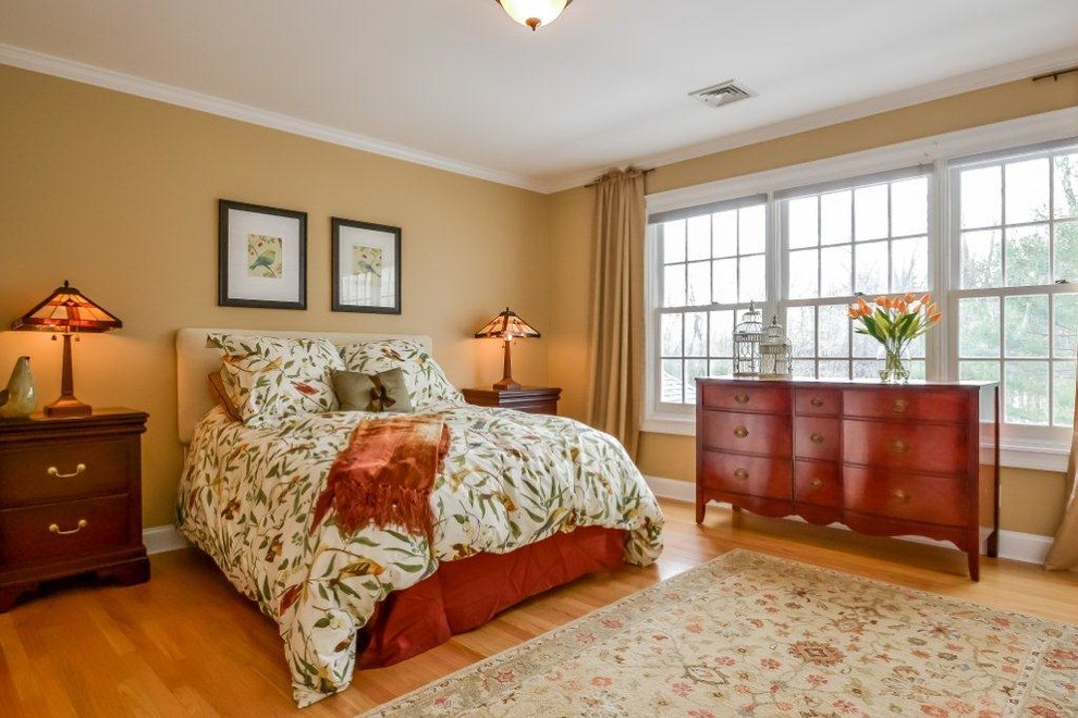 ニューヨークにある広いトラディショナルスタイルのおしゃれな客用寝室 (茶色い壁、無垢フローリング、暖炉なし、茶色い床) のインテリア