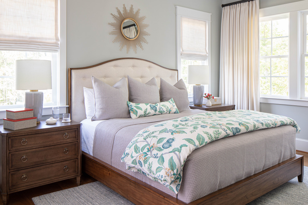 Ejemplo de dormitorio principal clásico renovado de tamaño medio sin chimenea con paredes grises, suelo de madera en tonos medios y suelo marrón