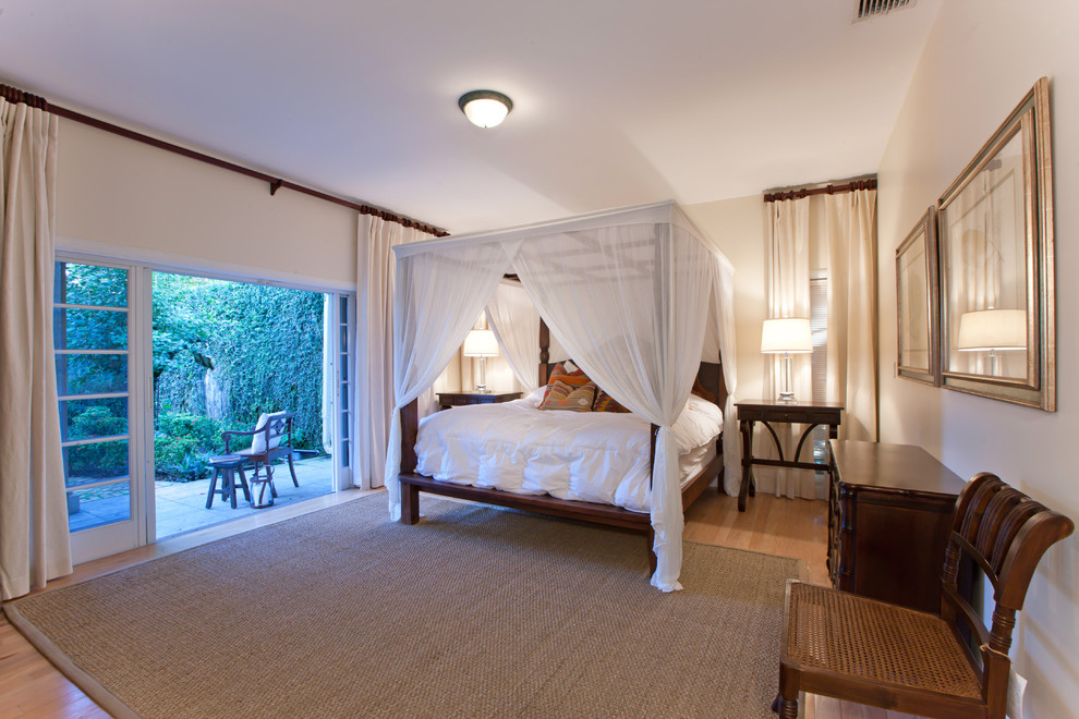 World-inspired bedroom in Other with beige walls and light hardwood flooring.