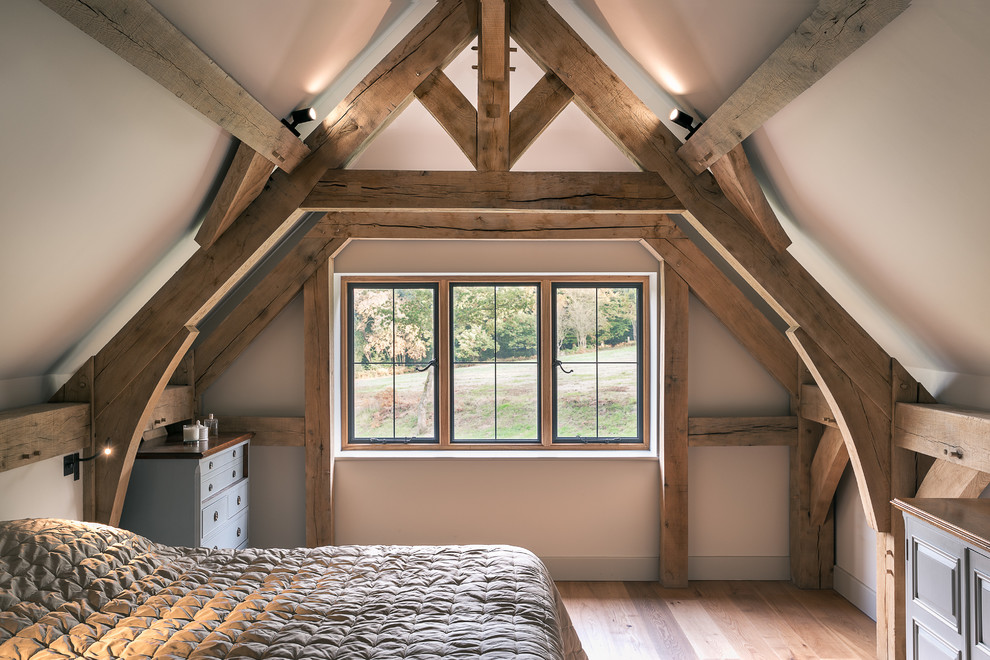 Example of a mid-sized mountain style master medium tone wood floor bedroom design in Surrey with white walls and no fireplace