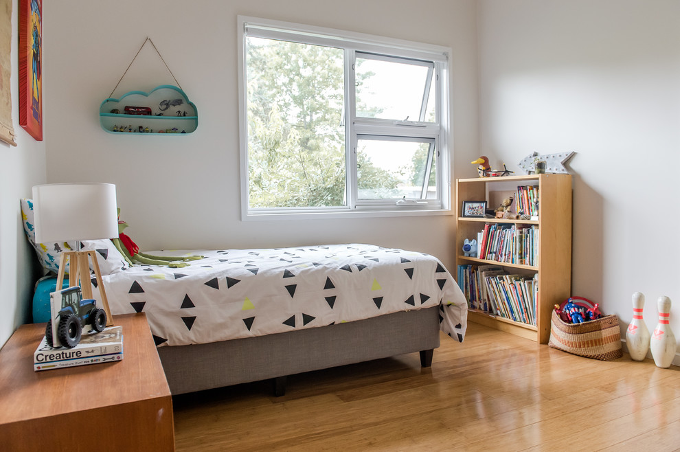 Imagen de habitación de invitados escandinava de tamaño medio sin chimenea con paredes beige y suelo de bambú