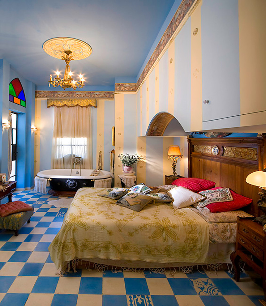 Photo of a mediterranean bedroom in Other with blue walls and multi-coloured floors.