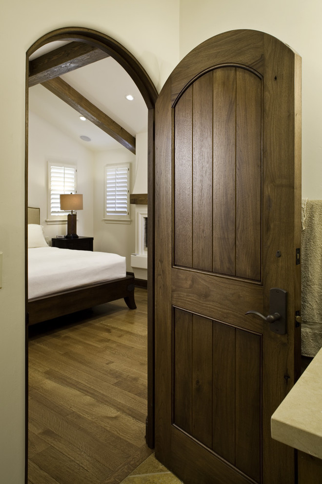 Imagen de dormitorio mediterráneo con suelo de madera en tonos medios
