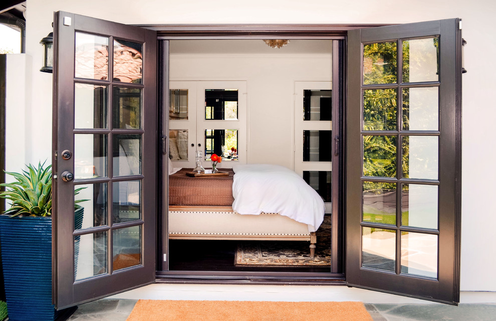 Mid-sized tuscan guest dark wood floor and brown floor bedroom photo in Los Angeles with white walls and no fireplace