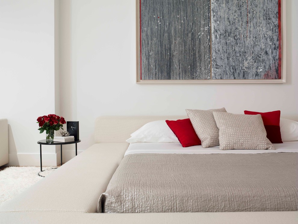 This is an example of a contemporary bedroom in New York with white walls.