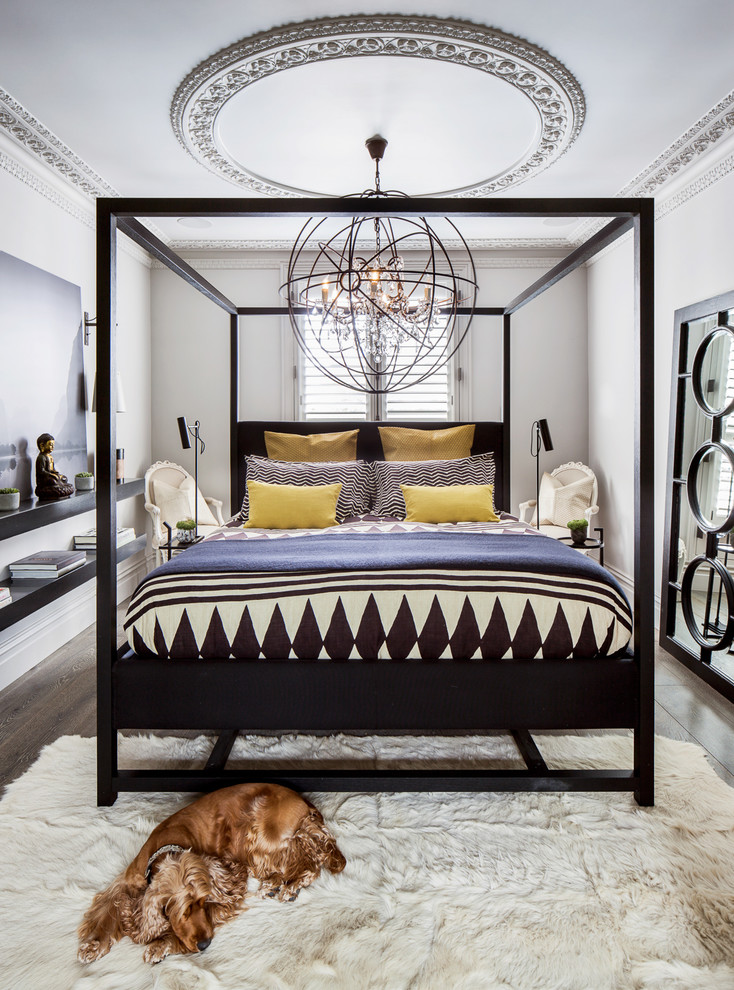 Mittelgroßes Eklektisches Schlafzimmer mit weißer Wandfarbe, braunem Holzboden und braunem Boden in London
