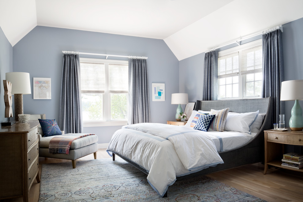 Large transitional guest medium tone wood floor bedroom photo in New York with blue walls