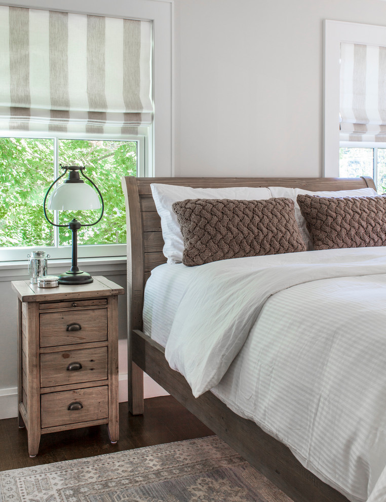 Modelo de habitación de invitados clásica de tamaño medio con paredes beige y suelo de madera en tonos medios