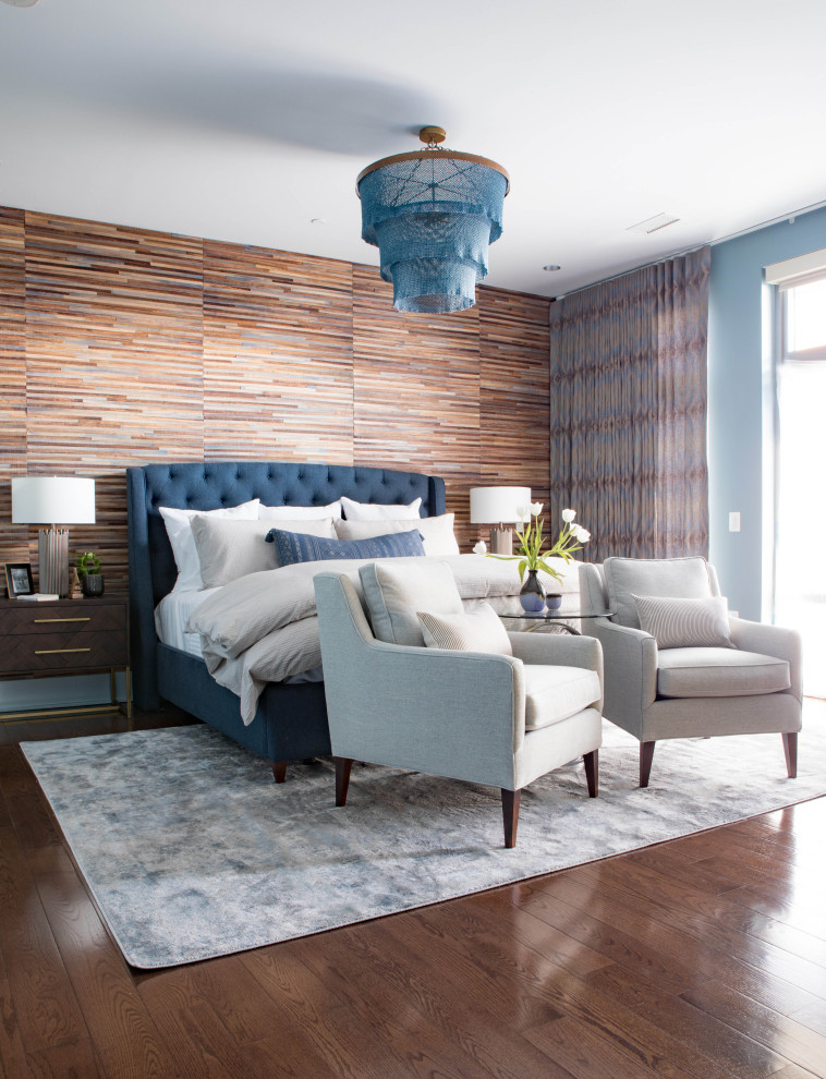Exemple d'une grande chambre parentale chic avec un mur bleu, un sol en bois brun, aucune cheminée et un sol marron.