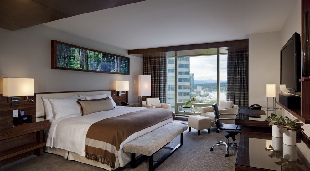 Cette image montre une chambre d'amis design de taille moyenne avec un mur beige et parquet foncé.