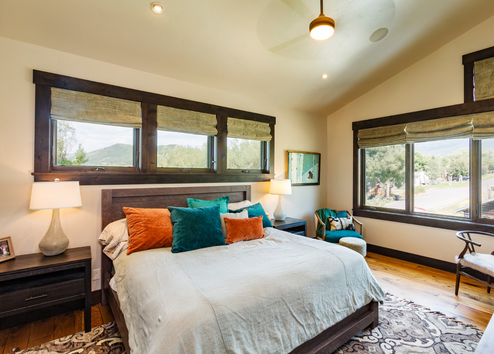Ispirazione per una camera da letto stile rurale con pareti beige, pavimento in legno massello medio e pavimento marrone
