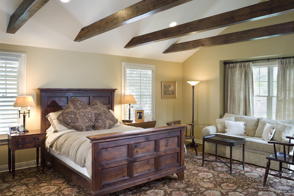 Diseño de dormitorio principal tradicional grande sin chimenea con paredes beige y suelo de madera en tonos medios