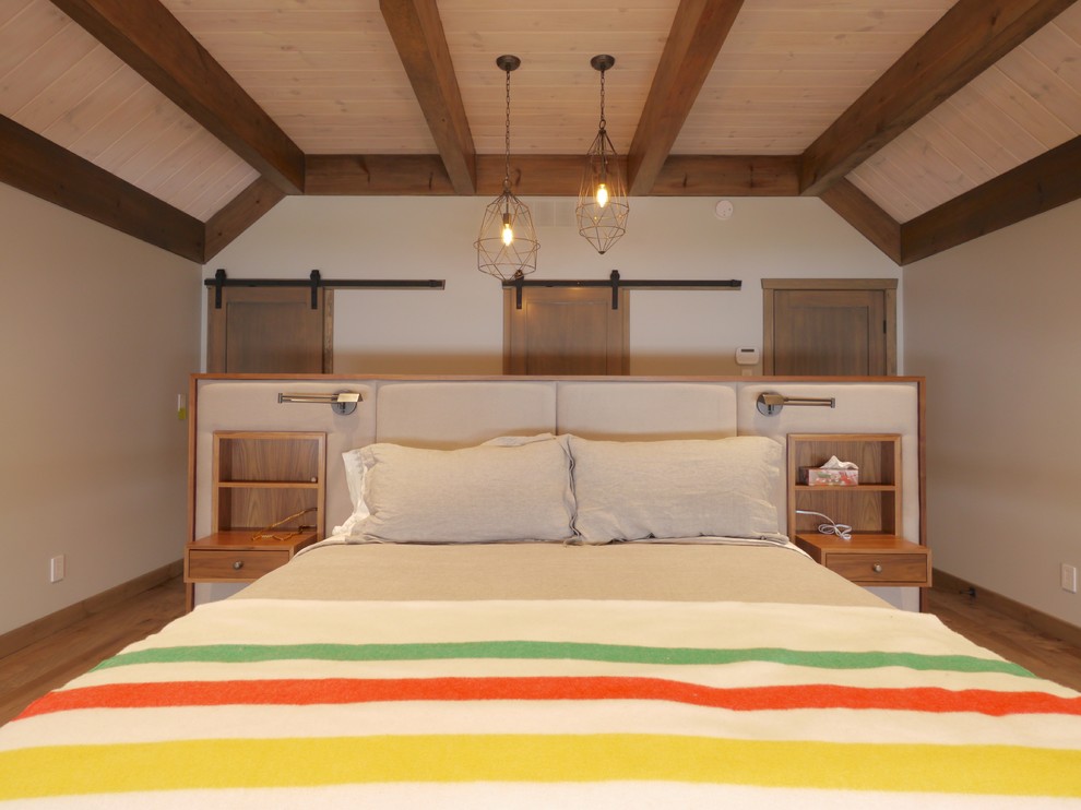 Foto de dormitorio tipo loft rural grande sin chimenea con paredes beige, suelo de madera en tonos medios y suelo marrón