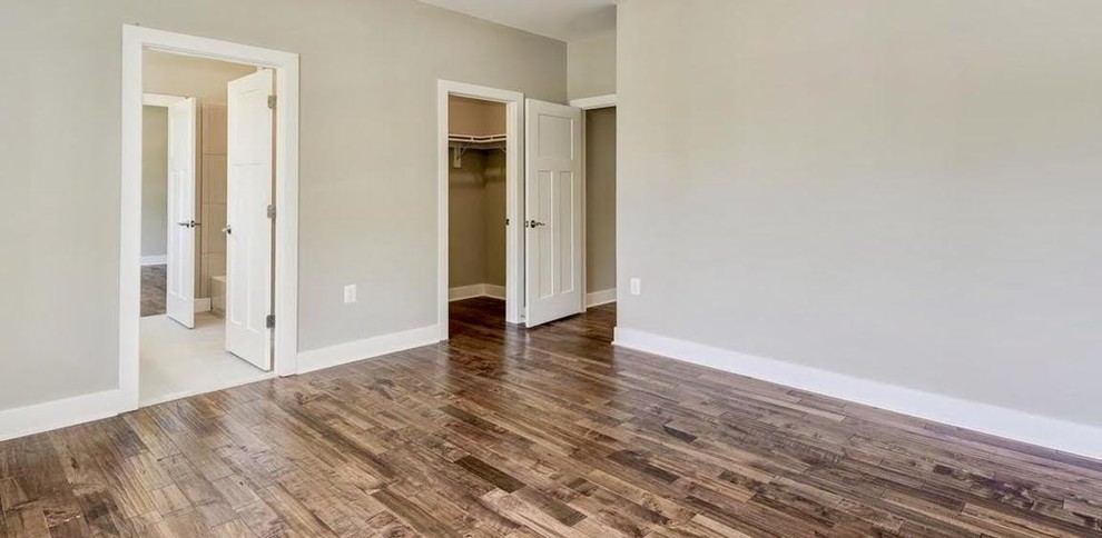 Medium sized contemporary master bedroom in DC Metro with beige walls, medium hardwood flooring, no fireplace and brown floors.