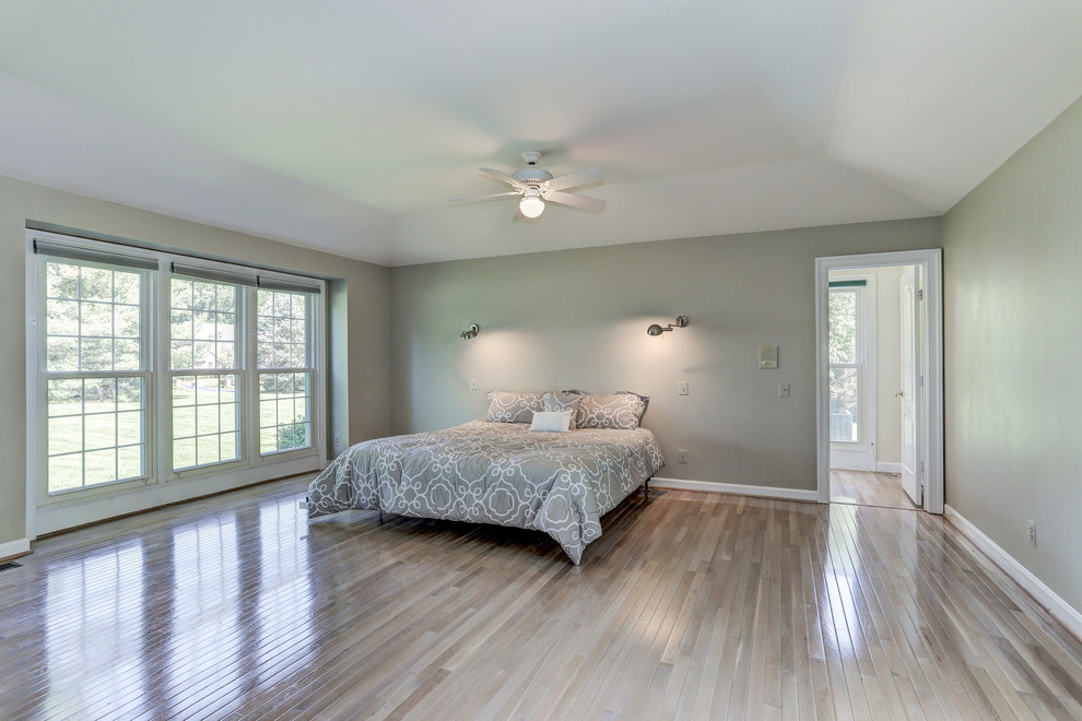 Imagen de dormitorio principal moderno grande con paredes verdes y suelo de madera clara